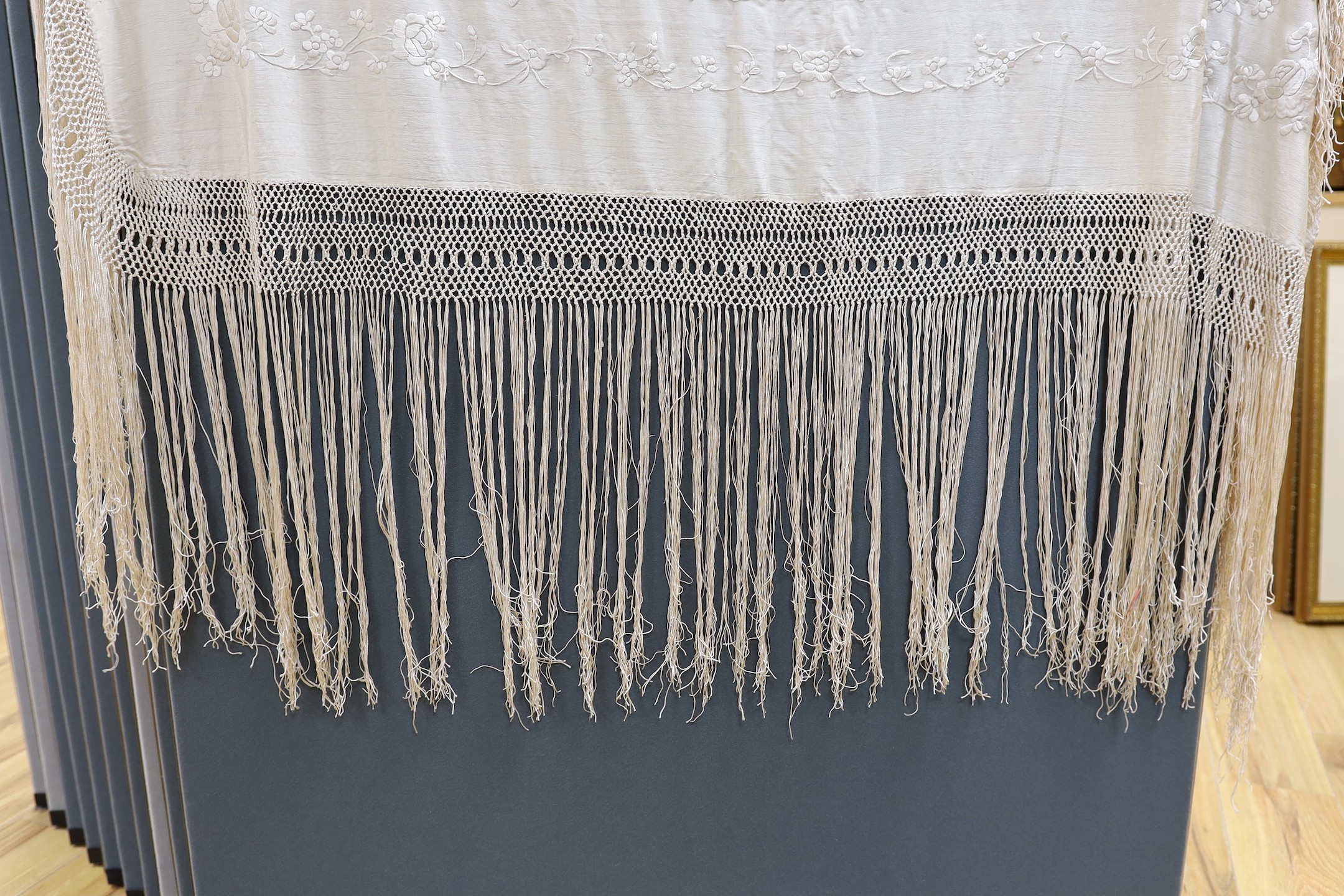 A Chinese late 19th century silk embroidered shawl, with cream on cream embroidery and a cream silk fringe, 140x134 cms